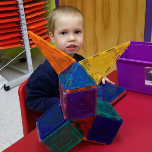 Preschool Boy plays with magnet blocks