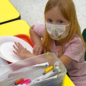 Preschool girl with drawing materials begins an art project