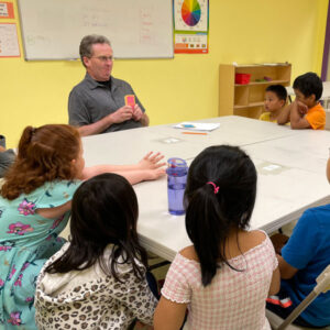 Students playing a card game with their teacher