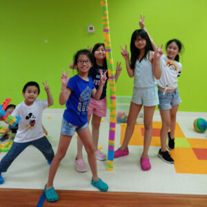 A group of children showing off their massive tower of duplo bricks