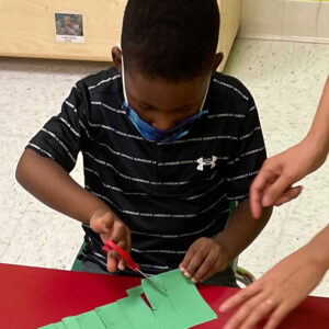 Boy cutting paper at Kiddosland