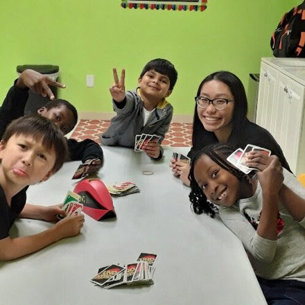 Group of kids playing a card game after school at Kiddosland