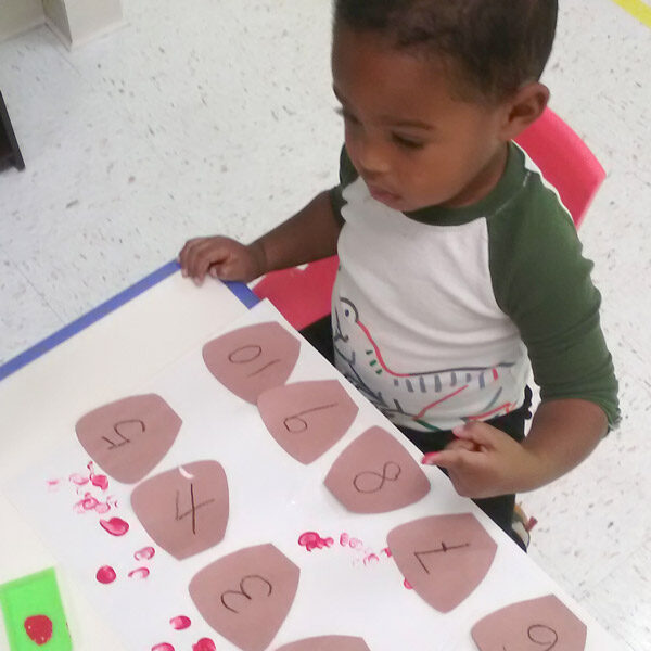 Mikey learning his numbers by making an art project at Kiddosland