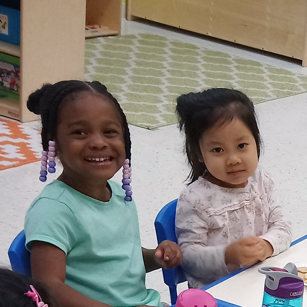Two preschool girls pose for a photo